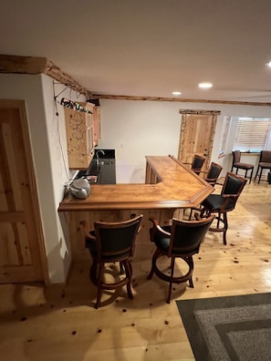 Une cuisine avec un bar en bois et six chaises.