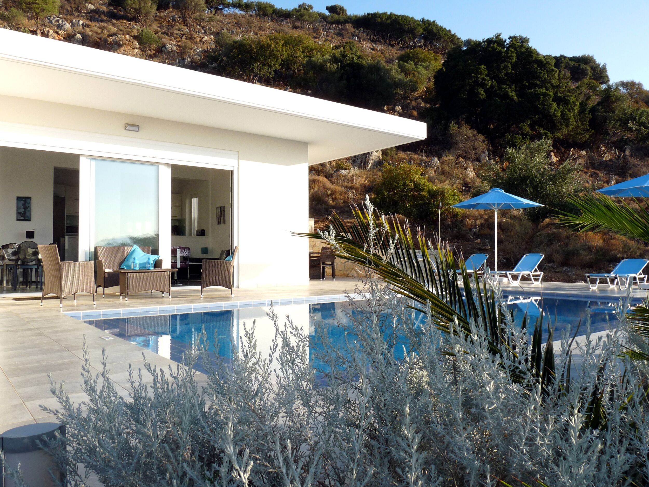 A modern pool area with lounge chairs and a dining area.