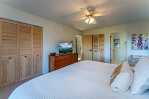A bedroom with a bed, wooden wardrobe, a dresser, a ceiling fan, and a painting on the wall. - Enjoy the View in the Journey House (Pisgah Forest)