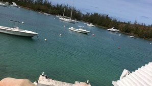 A view of a marina with several boats docked. There is a wooden deck leading to a building with a white exterior and a window. - Charming , Comfortable  Cottage Near Amenities (southampton)