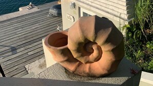 A terracotta sculpture on a concrete ledge overlooking a marina with boats. - Charming , Comfortable  Cottage Near Amenities (southampton)