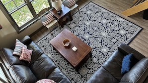A spacious living room with a large window, a fireplace, and a television. - 9 AM check in/9 PM check out, Custom Built, no shared walls free standing home (Redmond)