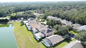 An aerial view of a residential area with houses, a lake, and a golf course. - Resort Community - Waterfront Home Next Door to Disney!  (Kissimmee)