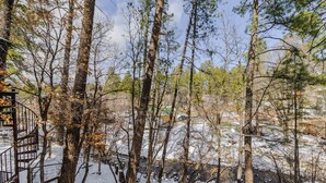 A snowy forest area with a spiral staircase leading up to a wooden structure. - RECHARGE,  Pets Welcome,  Fast Wifi,  Opt HOT TUB (Ruidoso)