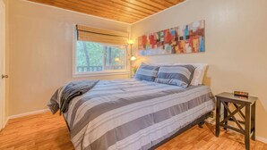 A bedroom with a bed, a window with blinds, a painting on the wall, and a clock on a nightstand. - RECHARGE,  Pets Welcome,  Fast Wifi,  Opt HOT TUB (Ruidoso)
