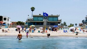 Een strand met een duikershut en strandparasols.