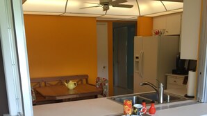 A compact kitchen with a sink, a small dining table, and a red bar stool. - Beautiful 1800 square foot Mid Century Home  (Venice)