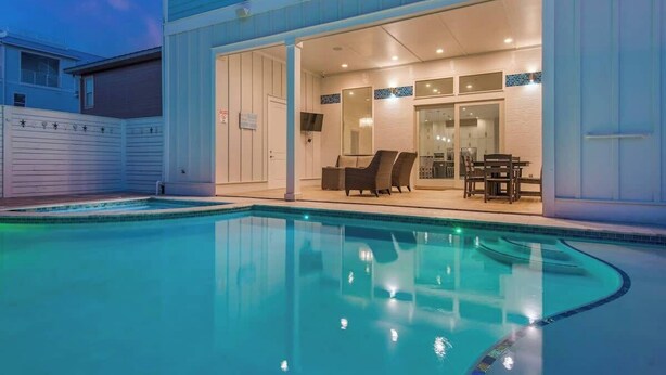 A modern house with a swimming pool, a covered patio with outdoor furniture, and a garage. - Good Day Sunshine | 100 Steps to Beach | 8 Free Beach Chairs through October! | Huge Private Pool & Lush Backyard (Miramar Beach)