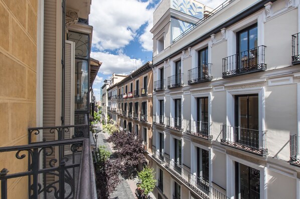 A narrow street flanked by multi-story buildings with balconies and windows.