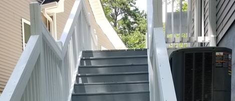 Een aantal buiten traptreden die leiden naar een gebouw met een witte balustrade.
