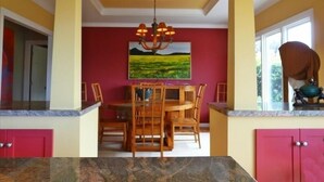 A dining area with a wooden table and chairs, a chandelier, and a painting on the wall. - Ocean View Retreat in Carmel Meadows w/ Hot Tub. Walk to Trails & Beach! (Carmel)