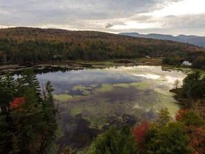 A serene lake surrounded by dense forest with autumn foliage. - Gore Mountain Chalet - Moments From Adventure! (Ski, Hike, Explore) (North Creek)