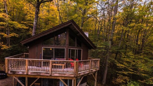A wooden cabin with a balcony, surrounded by trees. - Gore Mountain Chalet - Moments From Adventure! (Ski, Hike, Explore) (North Creek)