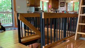 A wooden deck with a railing, a microwave, and a window overlooking greenery. - Gore Mountain Chalet - Moments From Adventure! (Ski, Hike, Explore) (North Creek)