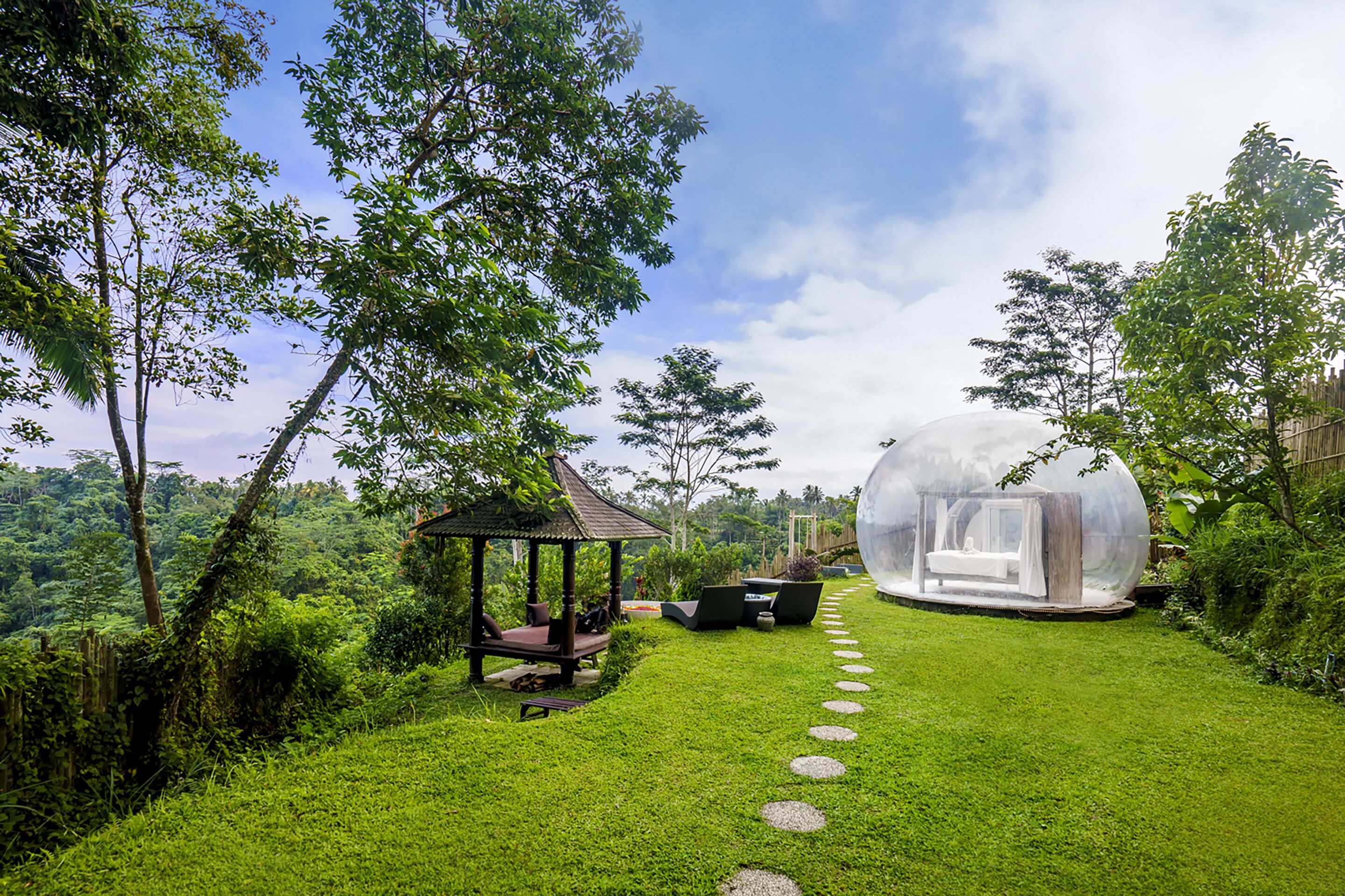 Ein friedlicher Garten mit einem Pavillon, einer transparenten Sphäre und blauem Himmel.