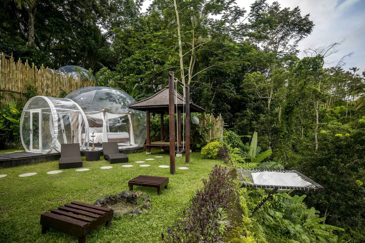 Un jardin doté de dômes transparents, d’un belvédère et d’un petit étang.