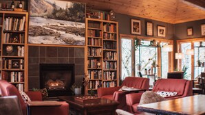 A cozy living room with a fireplace, bookshelves, and comfortable seating.