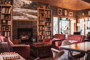 Una sala de estar acogedora con chimenea, estanterías y asientos cómodos.