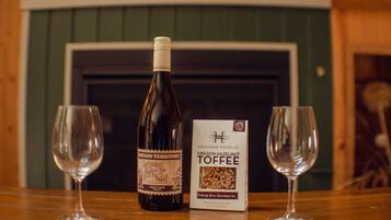 Une bouteille de vin aromatisé aux noisettes de l’Oregon et deux verres à vin vides sur une table en bois.