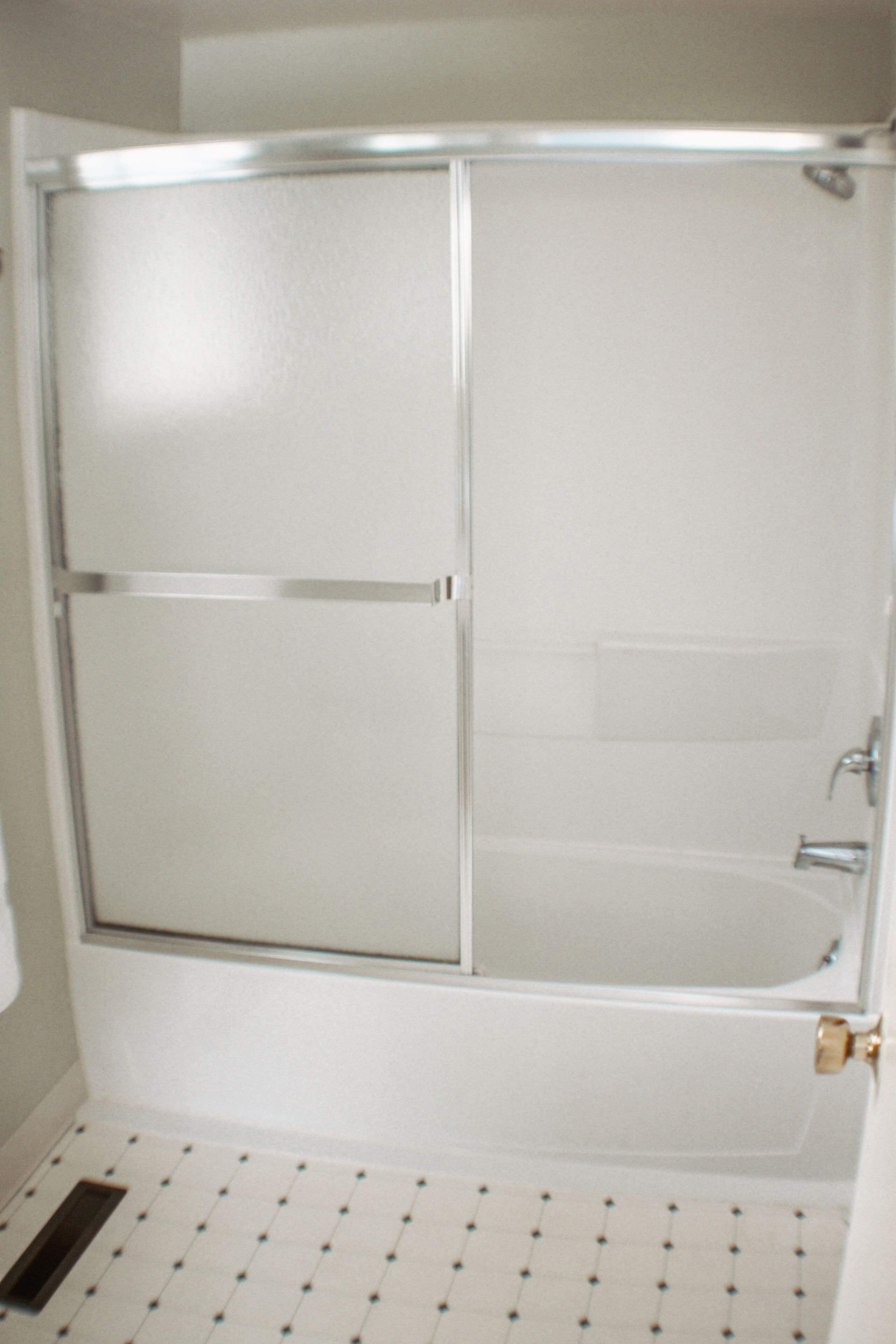 Un baño con cabina de ducha de vidrio, bañera y un inodoro.