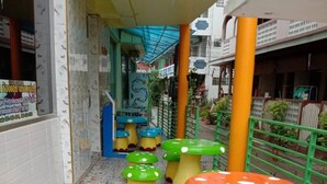 Un pasillo con taburetes con forma de hongo de colores alineados sobre un piso de baldosas.