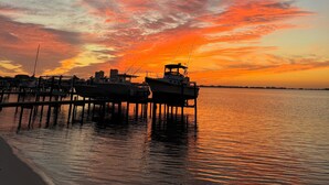A sunset view with boats docked at a pier. - Waterfront, Dog Friendly, Bring your boat + family beach and dock! (Pensacola Beach)