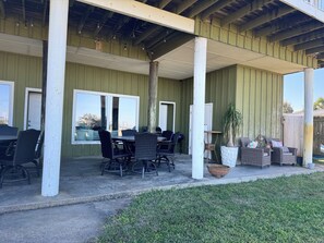 A covered patio area with outdoor seating and a view of the city. - Waterfront, Dog Friendly, Bring your boat + family beach and dock! (Pensacola Beach)