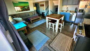 A compact living space with a sofa, coffee table, dining table, and kitchen area including a refrigerator and sink. - 3 bedrm Luxurious Apartment with Best View in Salt lake City and Private Hot Tub (Draper)