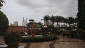 A fountain in a courtyard with a view of the Petronas Towers in the background. - Time Square By Trivaa (Kuala Lumpur)