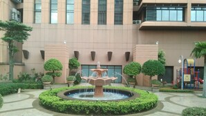 A courtyard with a central fountain, surrounded by neatly trimmed hedges and potted plants. - Time Square By Trivaa (Kuala Lumpur)
