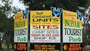 A sign for Ingham Tourist Park with directions and amenities listed. - Ingham Tourist Park (Ingham)