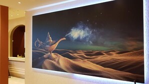 A large mural of a desert scene with a lamp post and a starry sky. - Hotel Imota (Neuwied)