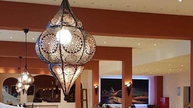 A restaurant with high tables and booths, overhead lighting fixtures, and a modern interior design. - Hotel Imota (Neuwied)