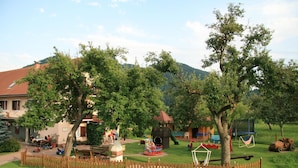 A playground with various play equipment, a picnic table, and a fenced area. - Erlebnisbauernhof Tschom (Sankt Kanzian am Klopeiner See)
