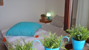Une chambre à coucher avec un lit, une table de chevet avec une lampe et des plantes en pot.