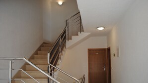 Un escalier avec des rampes en métal menant à une porte en bois située en bas.