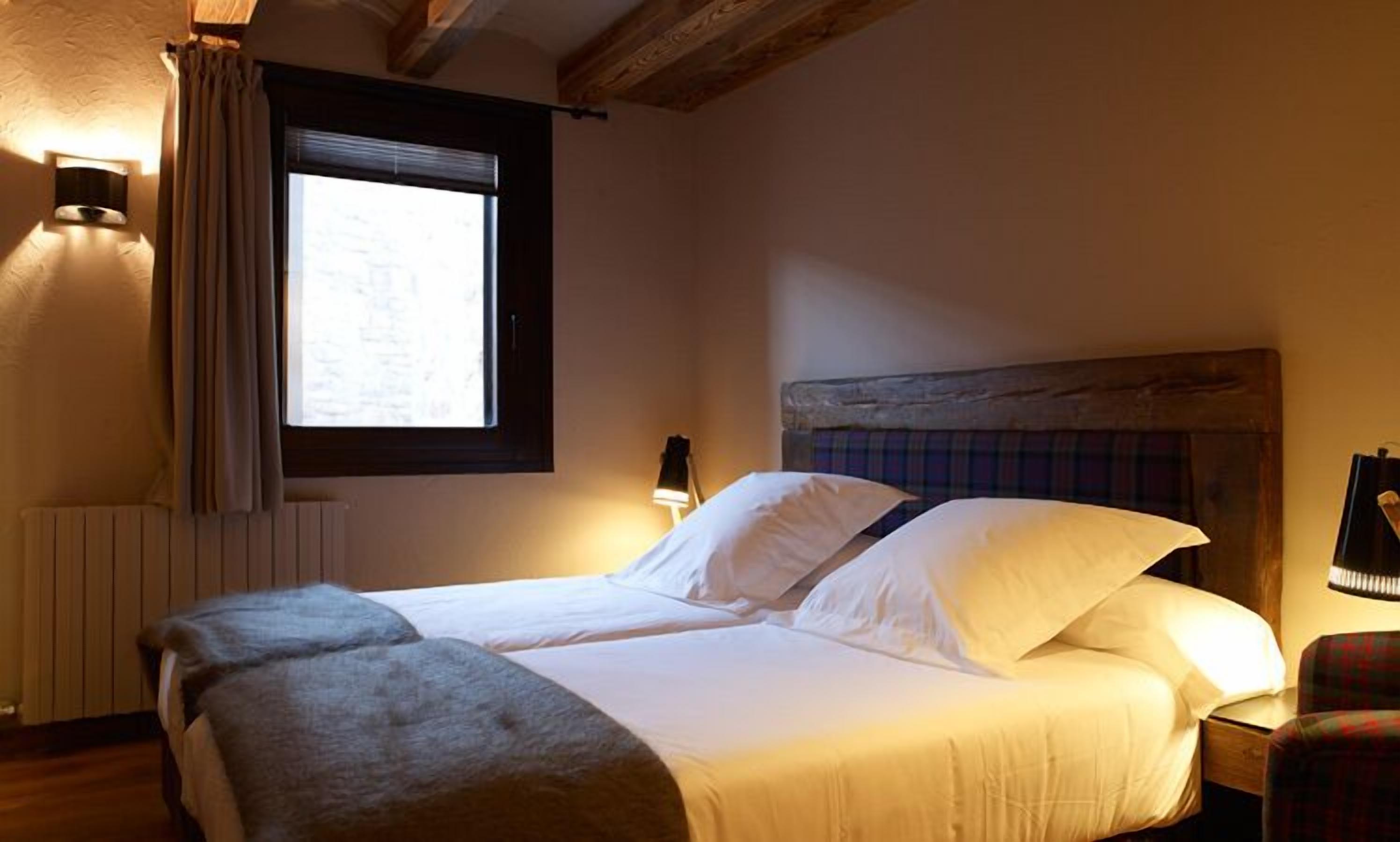 Una camera da letto con un letto, una finestra, una lampada e un termosifone.