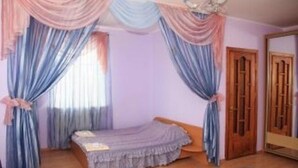A bedroom with a single bed, curtains, and a wooden wardrobe. - Kaufman (Konopnytsia)
