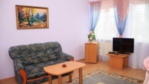 A living room with a sofa, a small table, a TV on a stand, and a painting on the wall. - Kaufman (Konopnytsia)