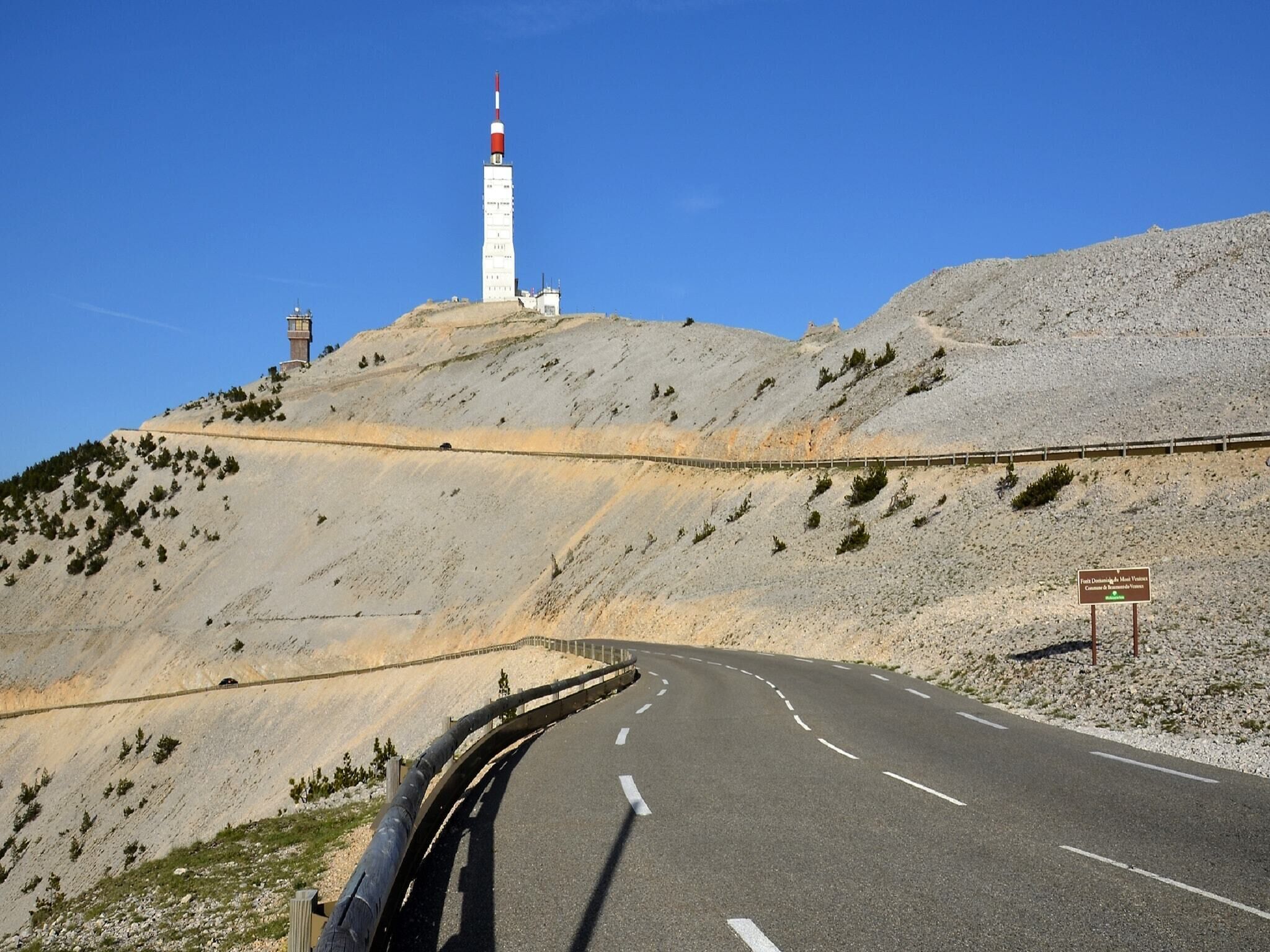 Eine kurvenreiche Straße mit einem Leuchtturm auf einem Hügel.
