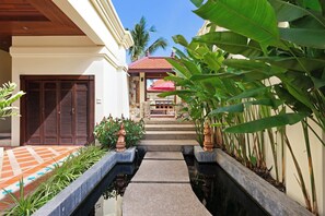 A pathway leading to a building with a tiled entrance, a red roof, and a small pool. - Private 6BR Tropical Estate near Nai Harn Beach (Rawai)