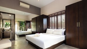 Una habitación de hotel moderna con una cama grande, una zona de estar y un espejo.