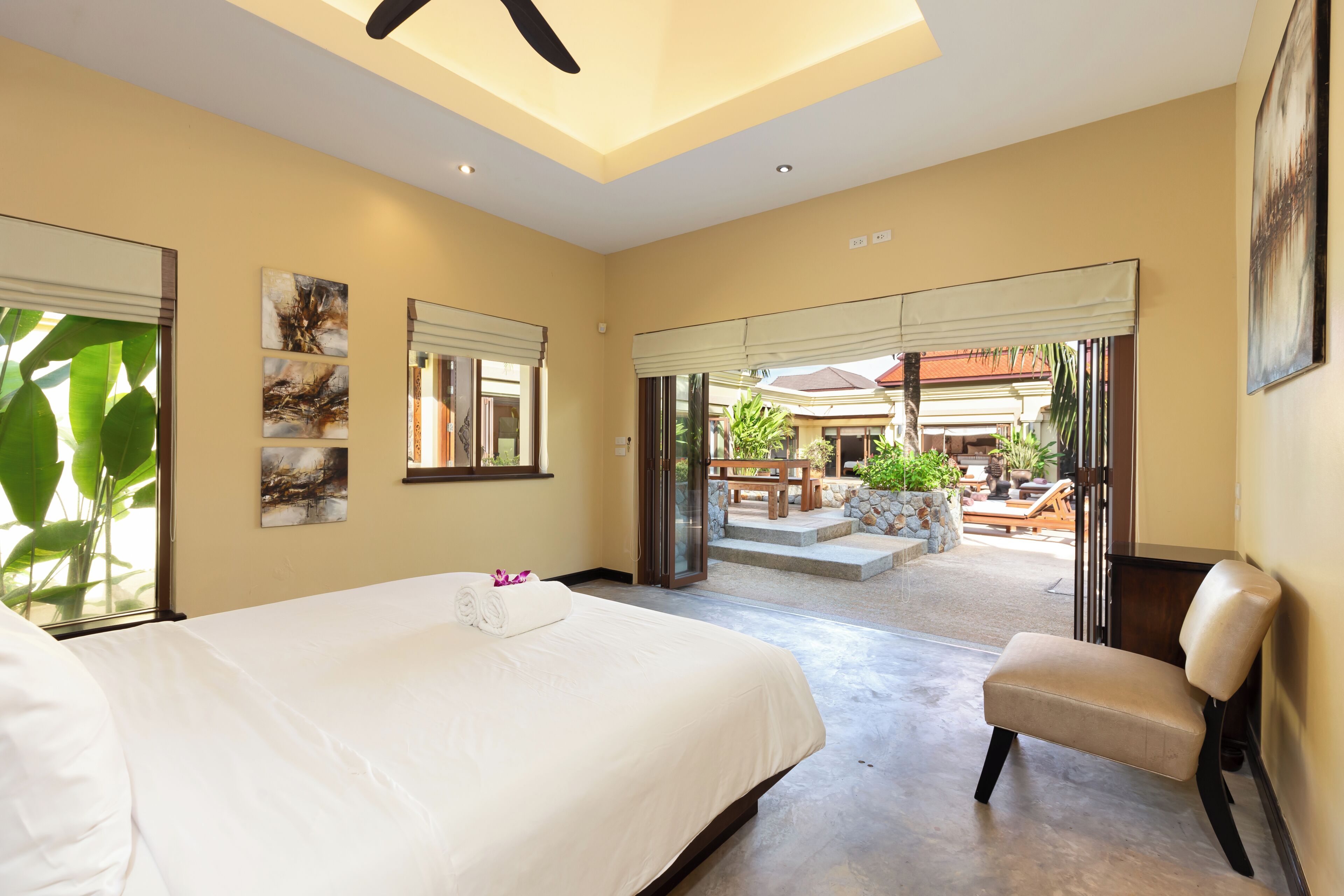 Een hotelkamer met een groot bed, een stoel en uitzicht op een terras.