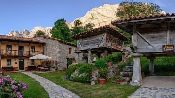 Un edificio rústico con fachada de piedra, un balcón y un letrero que dice "El Jermoso".