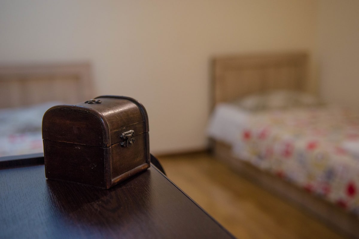 A small brown leather case on a wooden table in a hotel room.