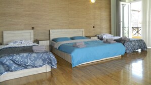 Une chambre d’hôtel avec deux lits, un plancher en bois et une grande fenêtre donnant sur un beau paysage.