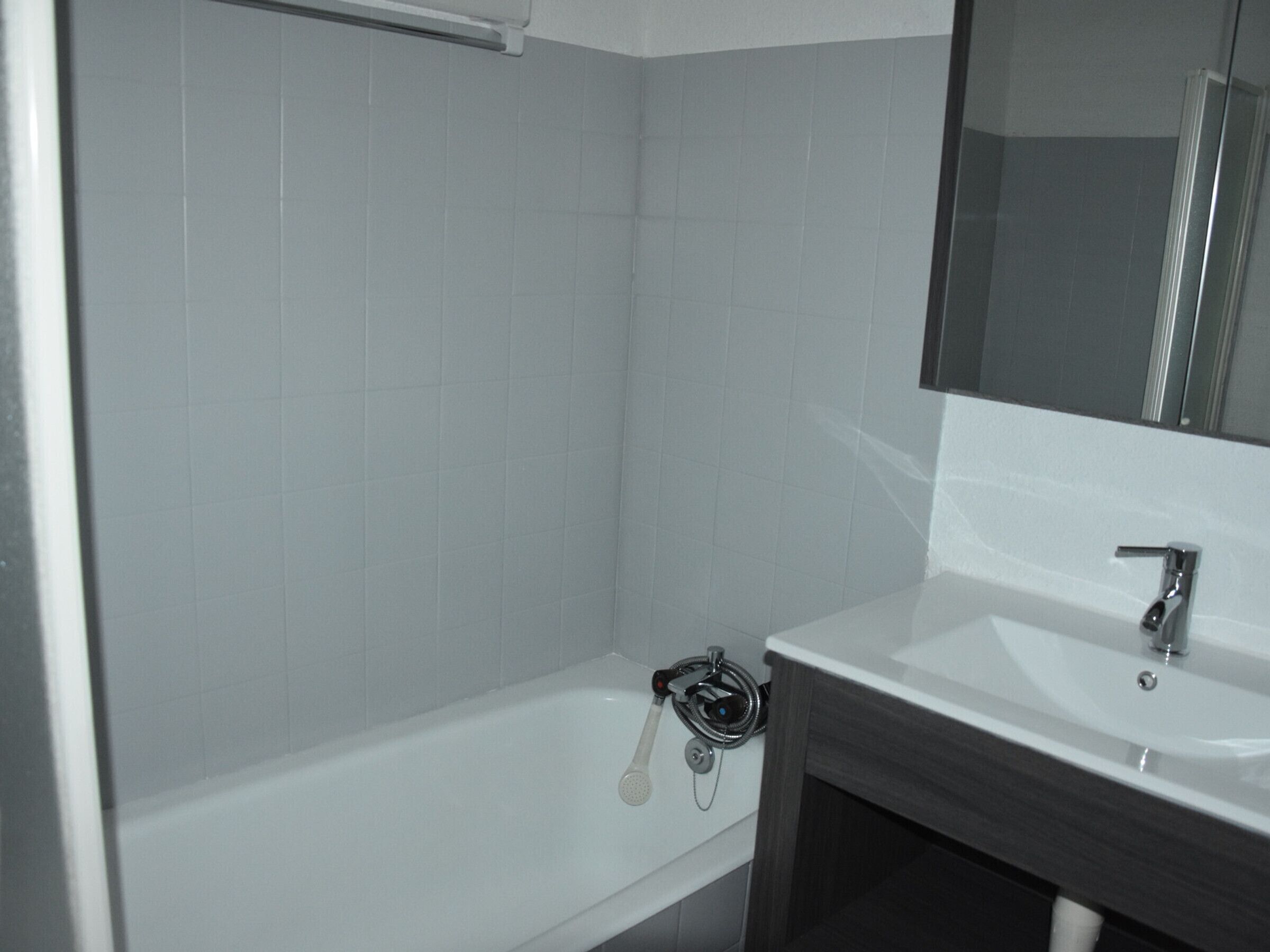 Ein Badezimmer mit einer weißen Badewanne, einem Waschbecken und einem Spiegel.