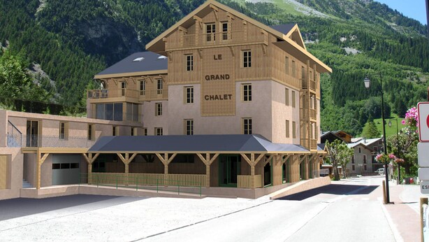 Un hotel con montañas al fondo, que muestra un letrero destacado que dice "LE GRAND CHALET".