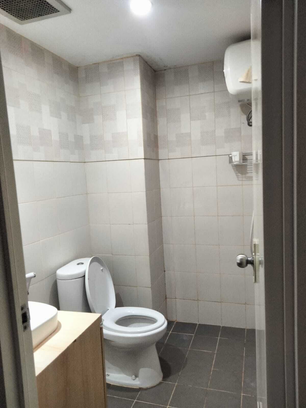 A bathroom with a toilet, a sink, and a shower area.
