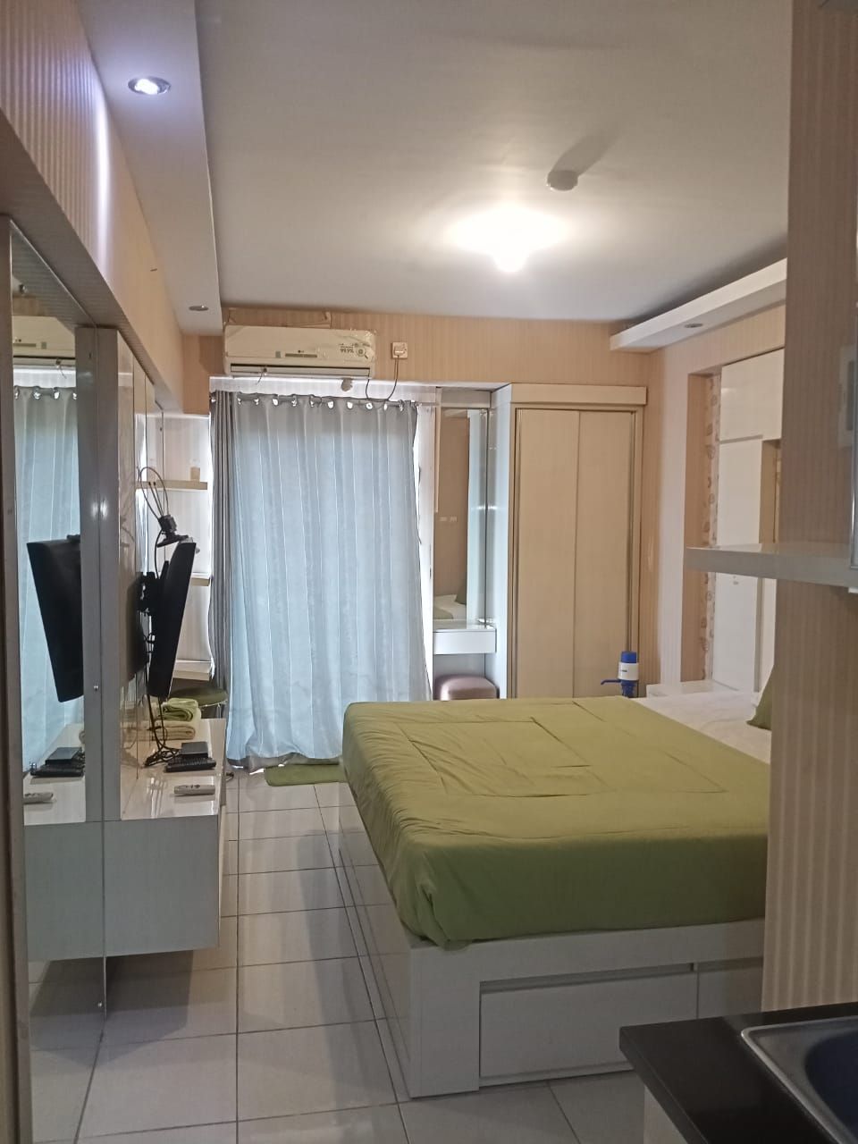 Ein Schlafzimmer mit einem Bett, einem Spiegel, einem Kleiderschrank und einem Badezimmer.